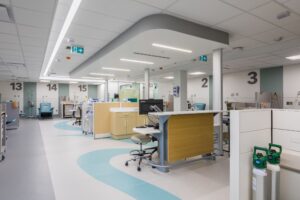 Emergency room with private patient areas, designed with bright lights and accents of teal.
