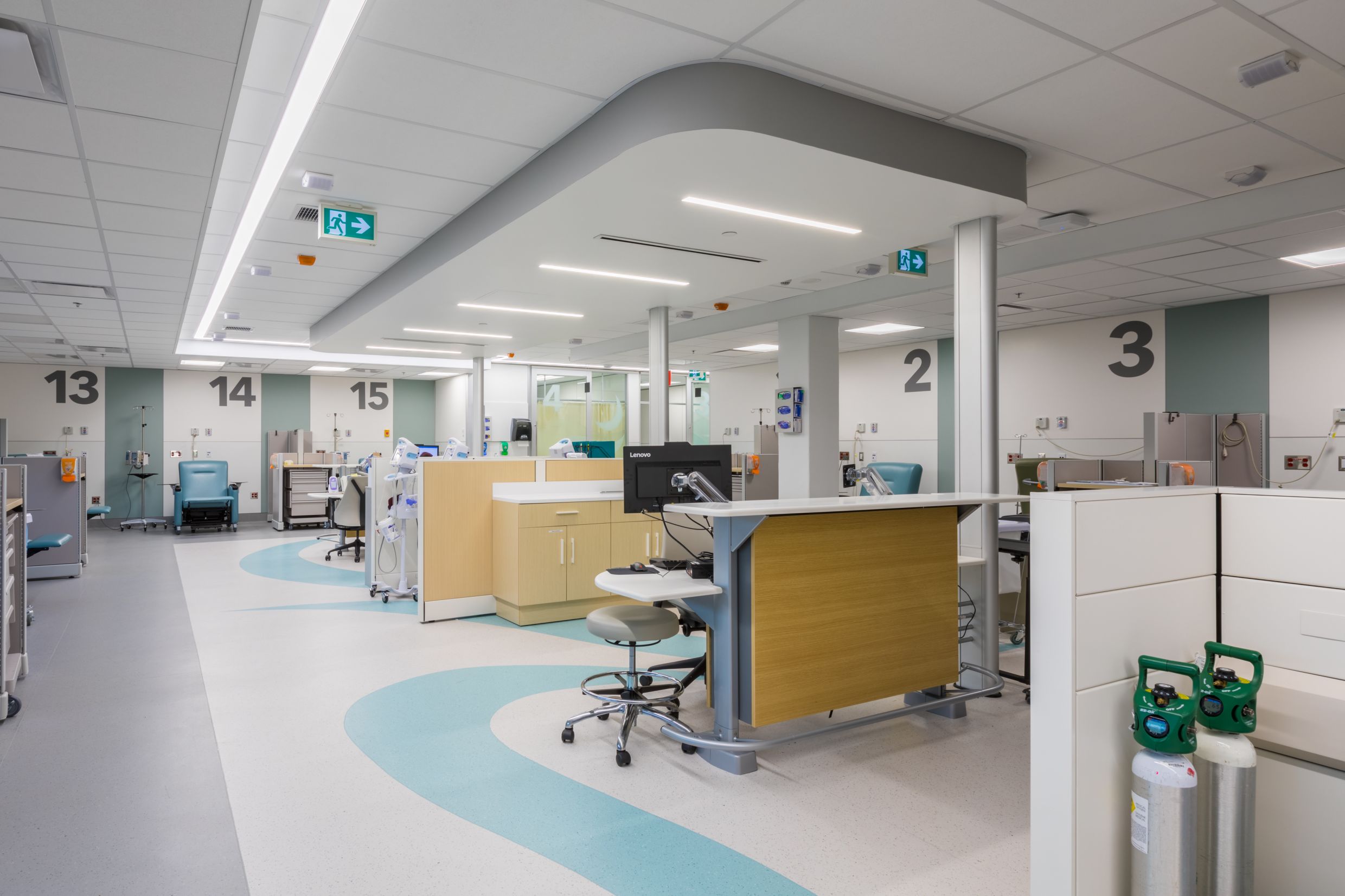 Emergency room with private patient areas, designed with bright lights and accents of teal.