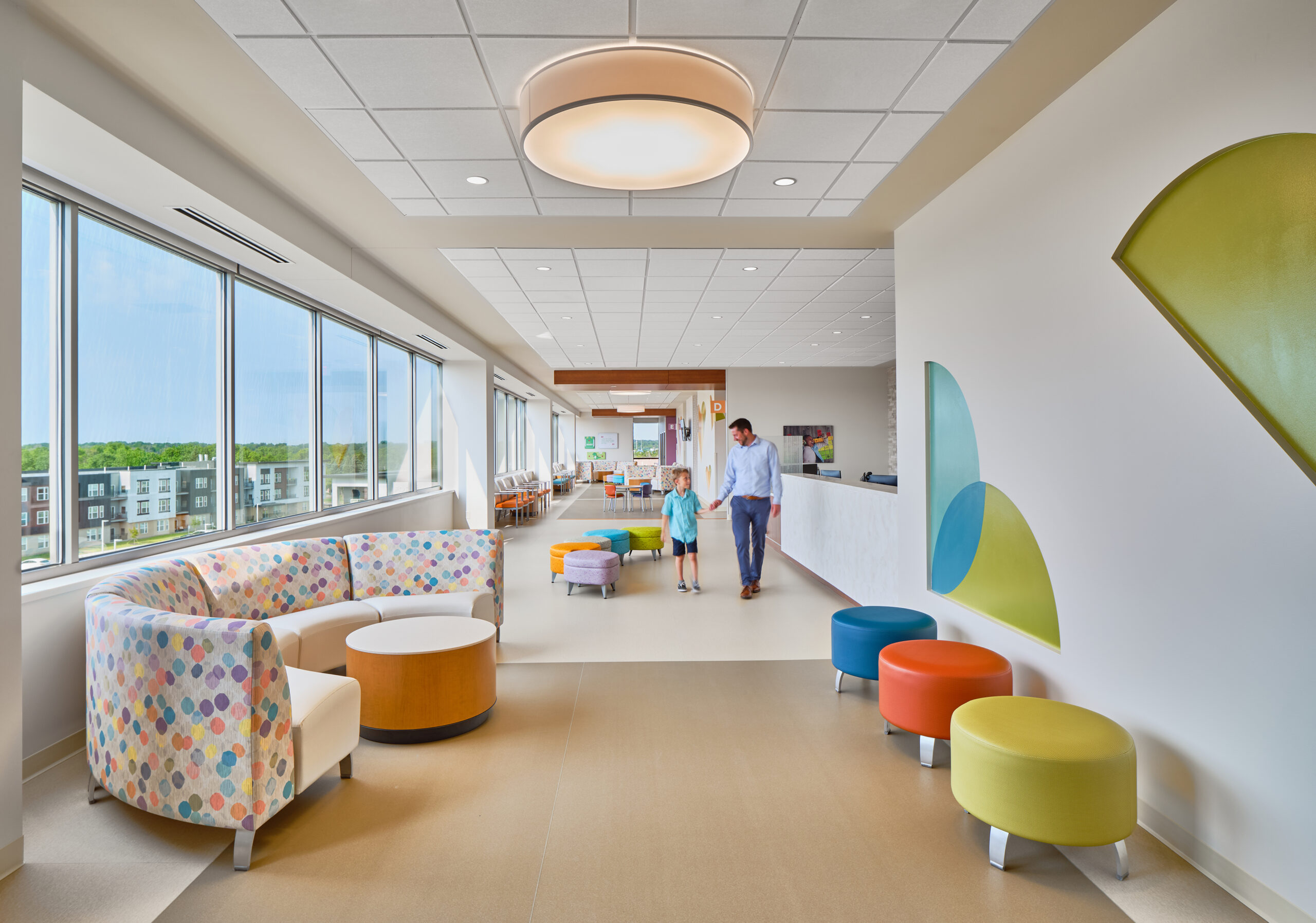 A bright hallway featuring colorful cushion seats and large windows.