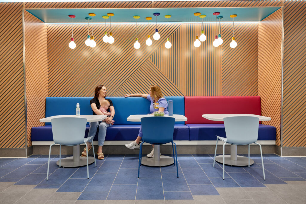 The design intent for the dining area and planter wall was to create a space with color and biophilic elements to continue building the revitalizing and welcoming ambiance throughout the hospital. 